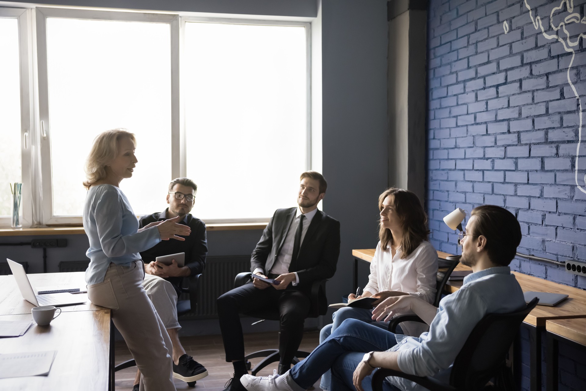 Coach businesswoman giving training to team at modern office