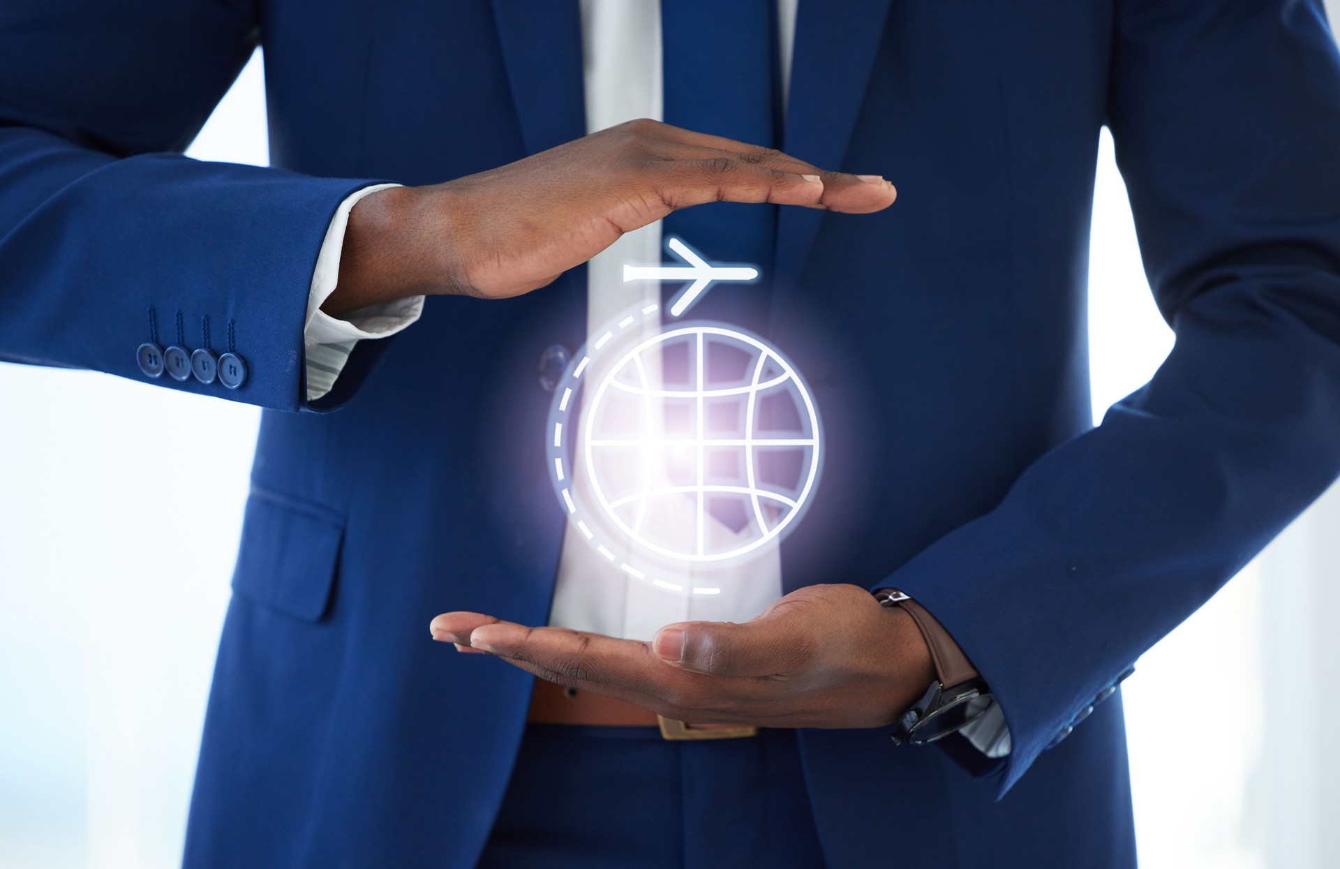 Shot of an unrecognisable businessman’s hands covering a graphic of an airplane traveling around the world